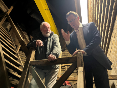 Alex Burghart MP on St Thomas's bell tower with bell ringer Chris Bailey